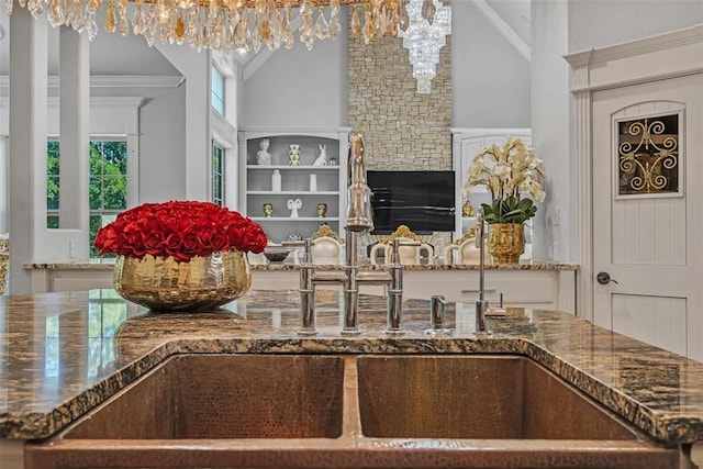 kitchen featuring sink, ornamental molding, and an inviting chandelier