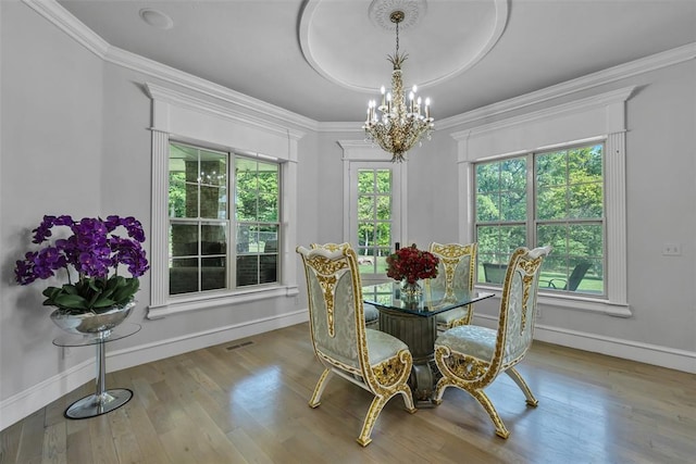 dining space with a chandelier, light hardwood / wood-style flooring, and crown molding