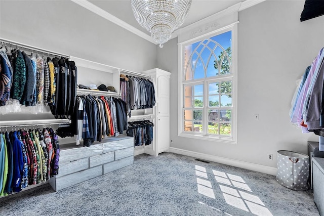 spacious closet with light colored carpet and a chandelier