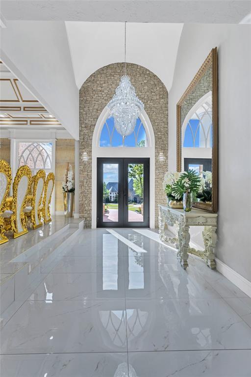 entrance foyer featuring french doors and an inviting chandelier