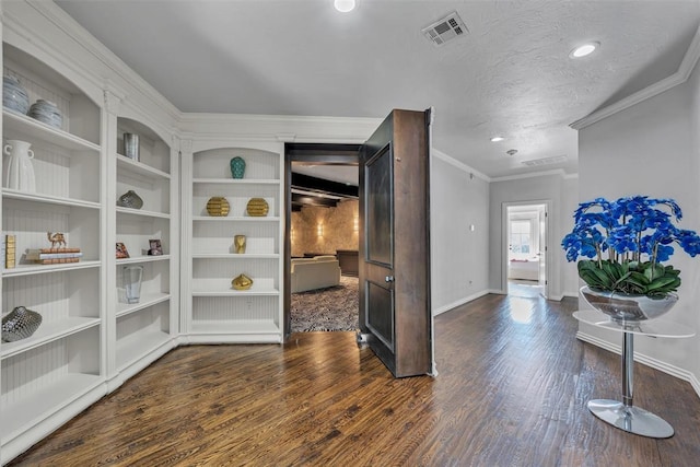 interior space with dark hardwood / wood-style floors, ornamental molding, and a textured ceiling