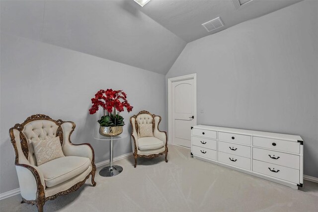 living area featuring light carpet and vaulted ceiling