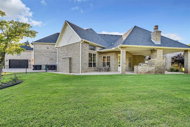 rear view of house with a lawn, a patio area, and exterior kitchen