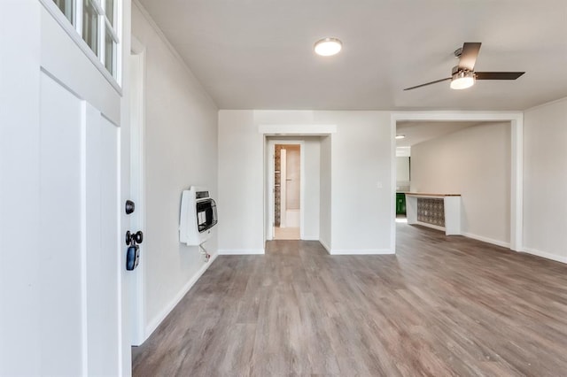 unfurnished living room with ceiling fan, hardwood / wood-style floors, and heating unit