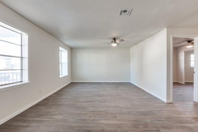 spare room with ceiling fan, plenty of natural light, and light hardwood / wood-style floors