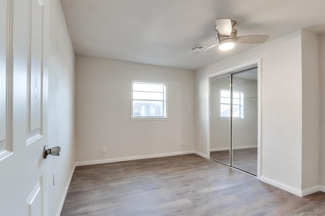 unfurnished bedroom with ceiling fan, a closet, and light hardwood / wood-style flooring