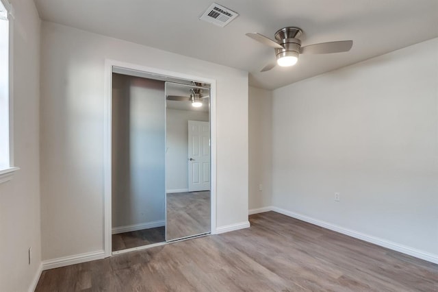 unfurnished bedroom with light hardwood / wood-style floors, a closet, and ceiling fan