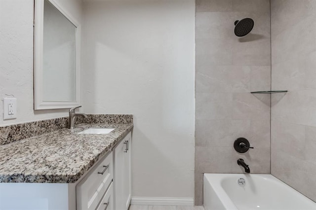 bathroom with tiled shower / bath and vanity