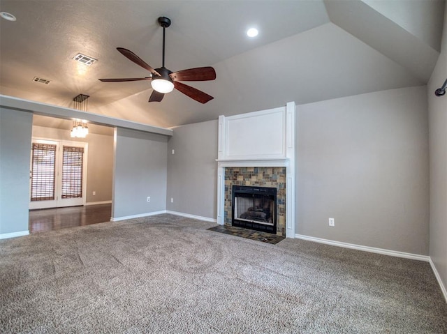 unfurnished living room with ceiling fan with notable chandelier, a fireplace, vaulted ceiling, and carpet floors