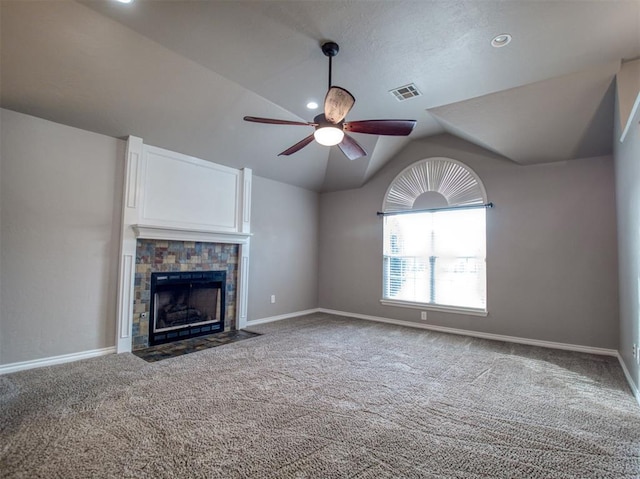 unfurnished living room with lofted ceiling, a tile fireplace, ceiling fan, and carpet