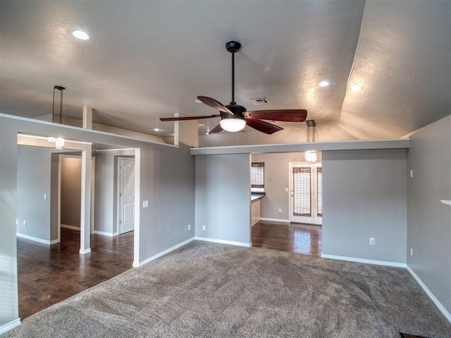 empty room with ceiling fan, lofted ceiling, and dark carpet