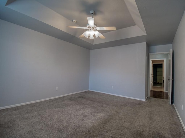 carpeted empty room featuring ceiling fan and a tray ceiling