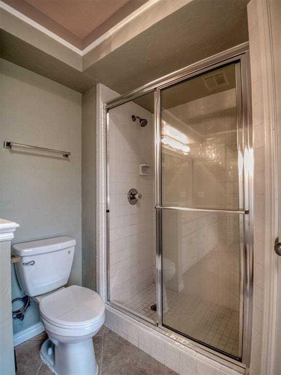 bathroom featuring tile patterned flooring, an enclosed shower, and toilet