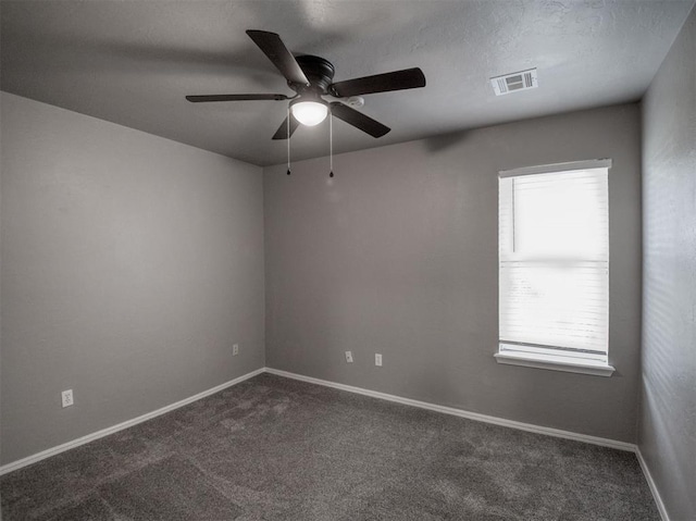 spare room with ceiling fan and dark carpet