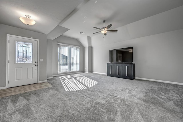 interior space featuring ceiling fan, vaulted ceiling, and carpet flooring