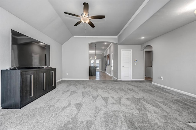 unfurnished living room with lofted ceiling, light colored carpet, ceiling fan with notable chandelier, and ornamental molding