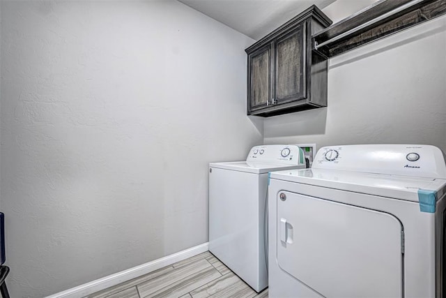 laundry area with cabinets and washing machine and clothes dryer