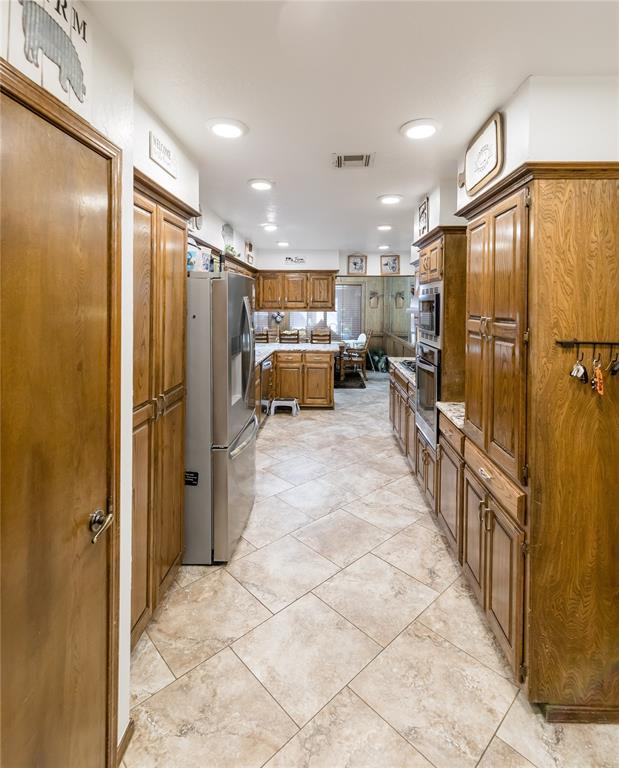 kitchen featuring stainless steel appliances and light tile patterned flooring