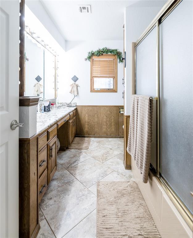 bathroom with vanity and bath / shower combo with glass door