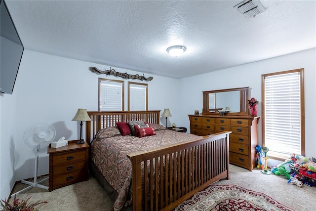 bedroom with light carpet and a textured ceiling