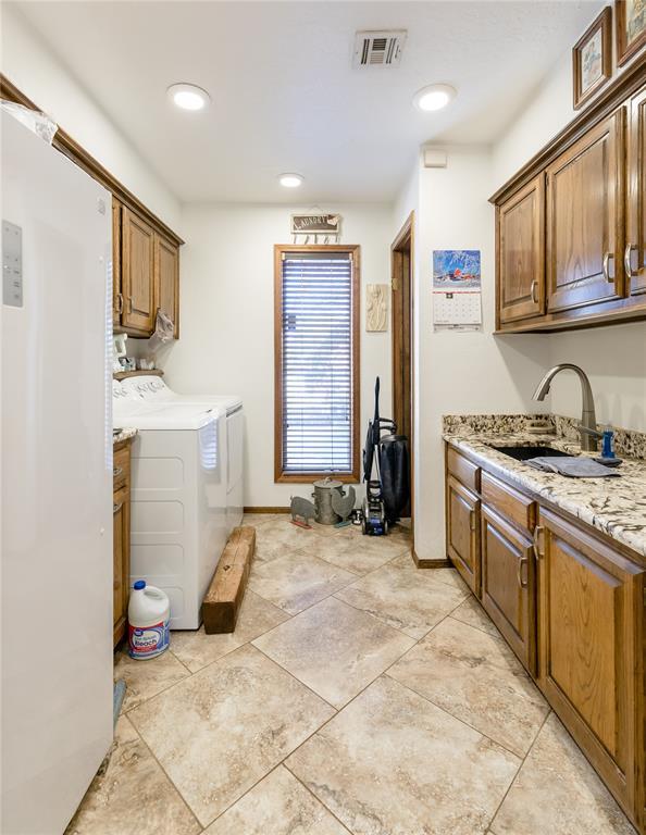 laundry area featuring cabinets, separate washer and dryer, and sink