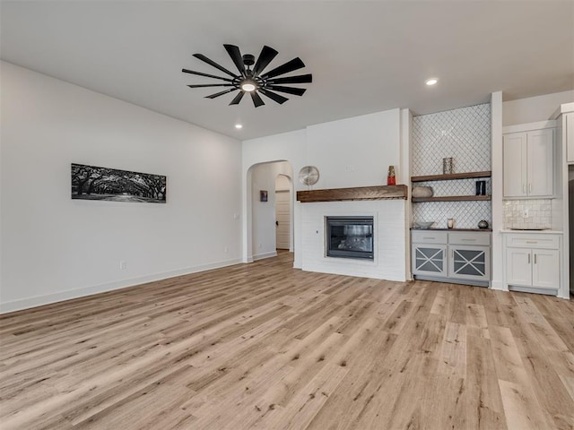 unfurnished living room with light hardwood / wood-style flooring and ceiling fan