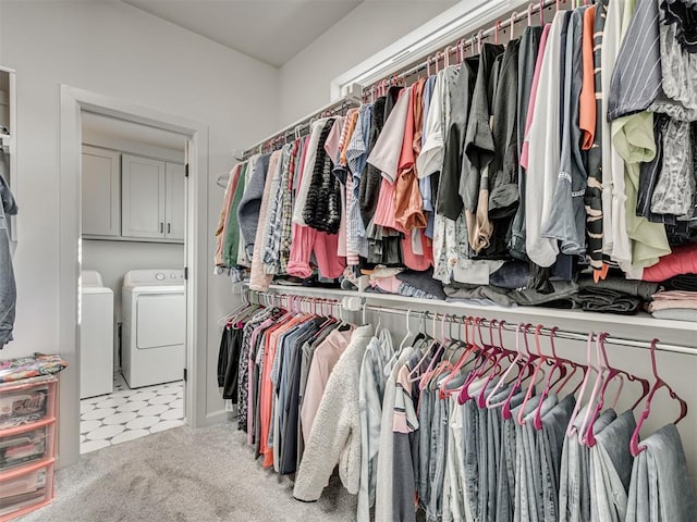 spacious closet with washing machine and clothes dryer and light carpet