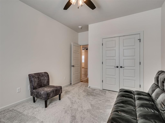 living area featuring ceiling fan and light colored carpet