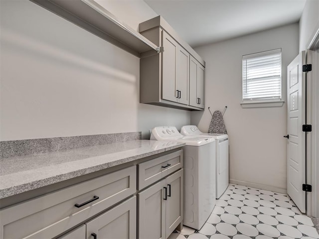 laundry area featuring washer and clothes dryer and cabinets