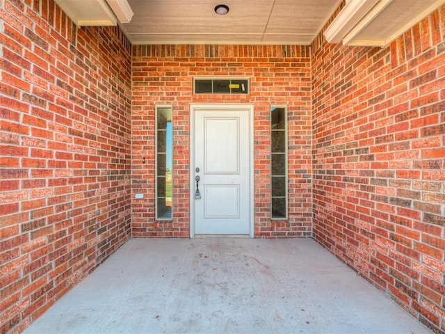 view of exterior entry featuring a patio area