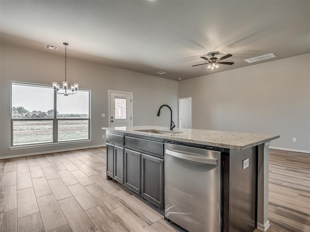 kitchen featuring dishwasher, a kitchen island with sink, ceiling fan with notable chandelier, sink, and decorative light fixtures