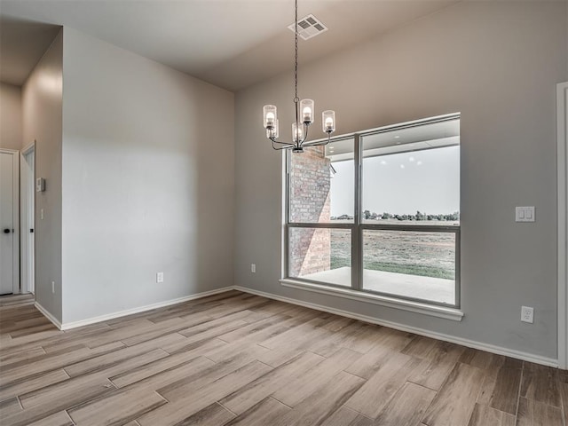 unfurnished dining area with an inviting chandelier