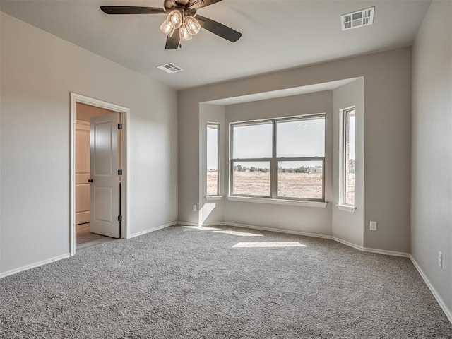 spare room with ceiling fan and light colored carpet