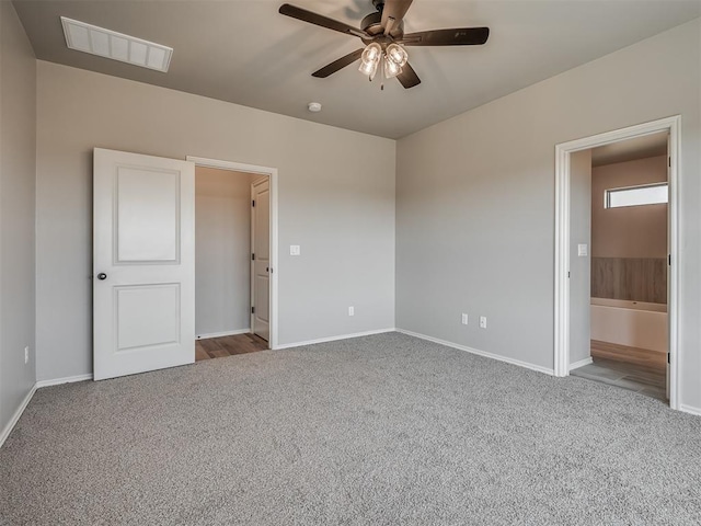 unfurnished bedroom featuring carpet floors, ensuite bathroom, and ceiling fan