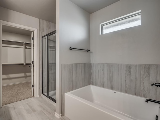 bathroom featuring hardwood / wood-style floors and plus walk in shower