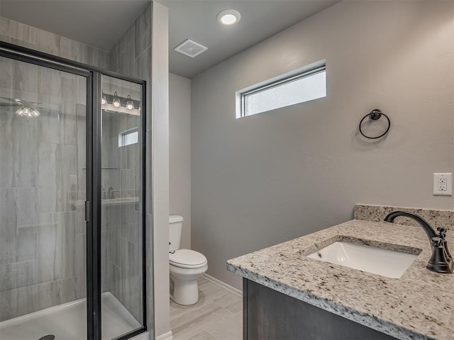 bathroom featuring an enclosed shower, vanity, and toilet