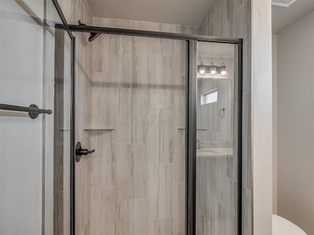 bathroom featuring toilet and an enclosed shower