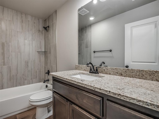 full bathroom with vanity, toilet, wood-type flooring, and tiled shower / bath combo