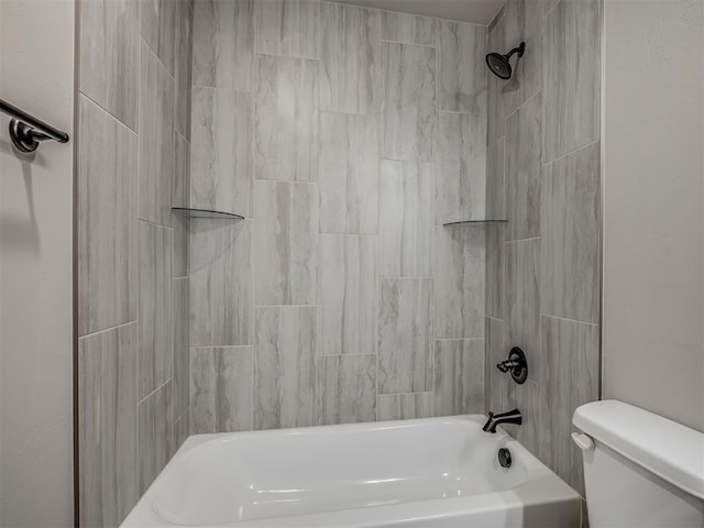 bathroom featuring tiled shower / bath combo and toilet