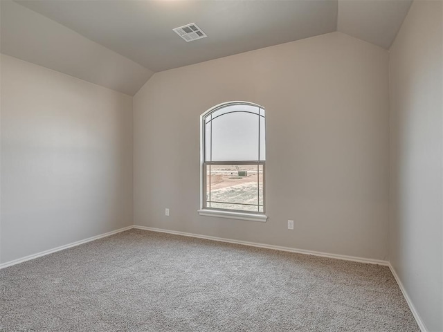 empty room featuring carpet flooring and vaulted ceiling