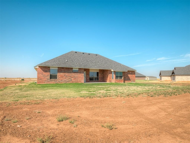 rear view of house featuring a yard