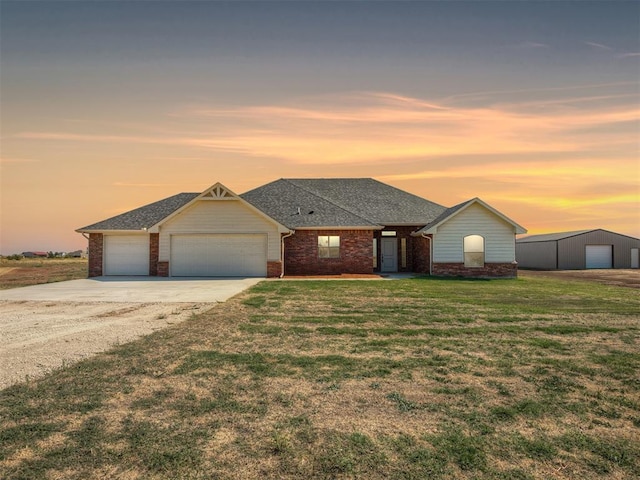 single story home featuring brick siding, a lawn, an attached garage, and concrete driveway