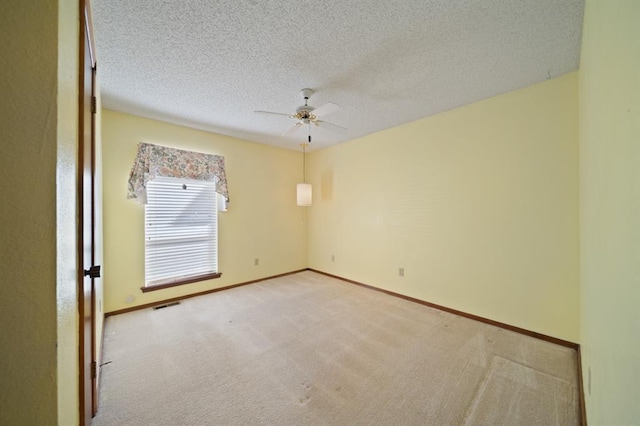 carpeted spare room featuring a textured ceiling and ceiling fan