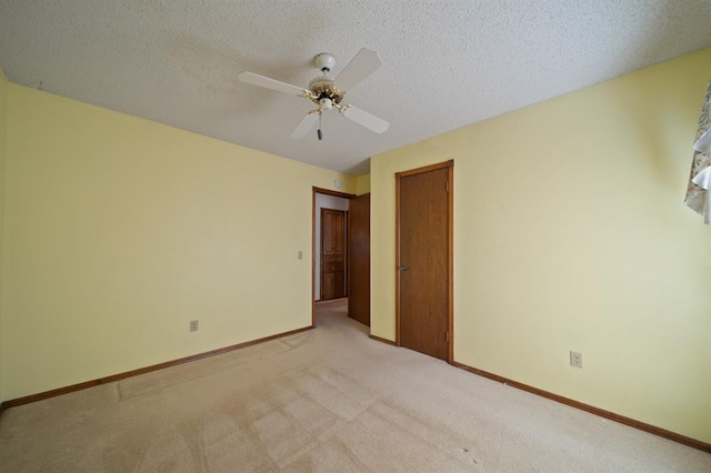 carpeted spare room featuring a textured ceiling and ceiling fan