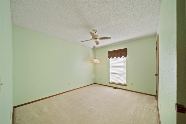 carpeted spare room featuring ceiling fan and a textured ceiling