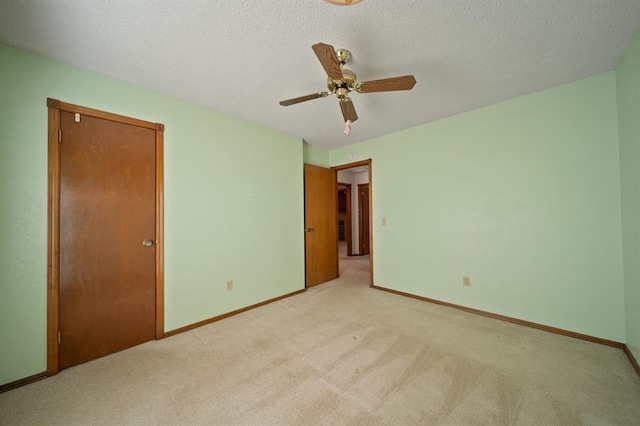 unfurnished bedroom featuring ceiling fan, light colored carpet, a closet, and a textured ceiling