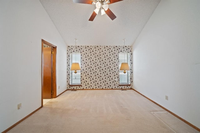 empty room featuring lofted ceiling, light colored carpet, and ceiling fan