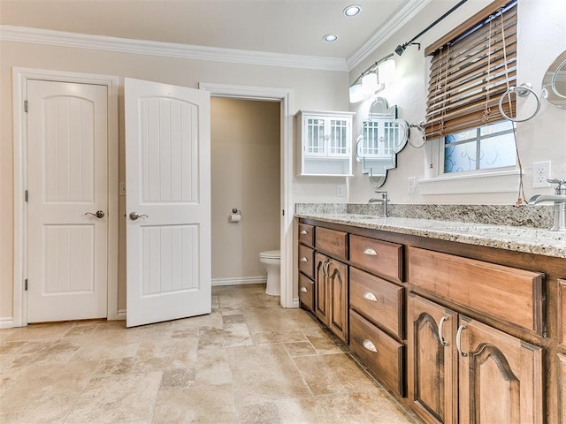 6704 Tall Oaks Dr, Oklahoma City, OK 73127 - full bath with stone tile floors, toilet, ornamental molding, baseboards, and vanity