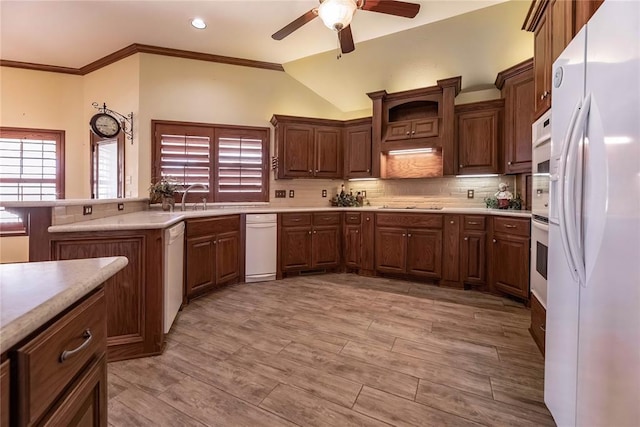 kitchen featuring crown molding, white appliances, backsplash, light hardwood / wood-style floors, and kitchen peninsula