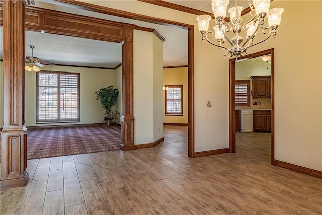 interior space featuring decorative columns, ornamental molding, hardwood / wood-style flooring, and ceiling fan with notable chandelier